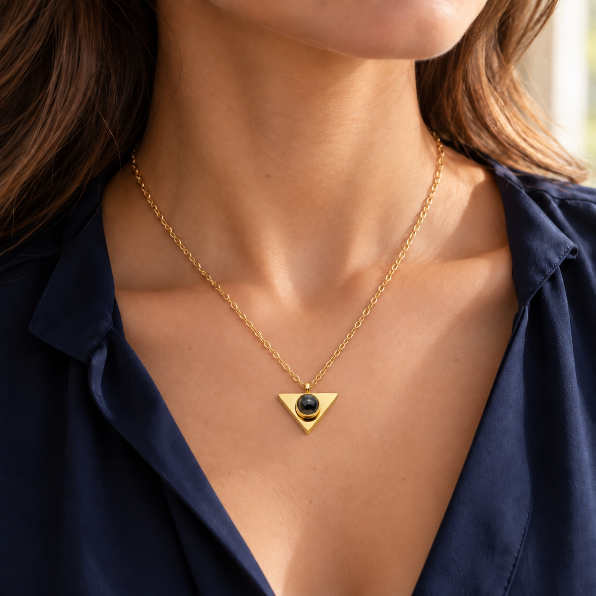 Frau trägt die goldfarbene Dreieck-Fotokette von 4MyLove zu einer dunkelblauen Bluse