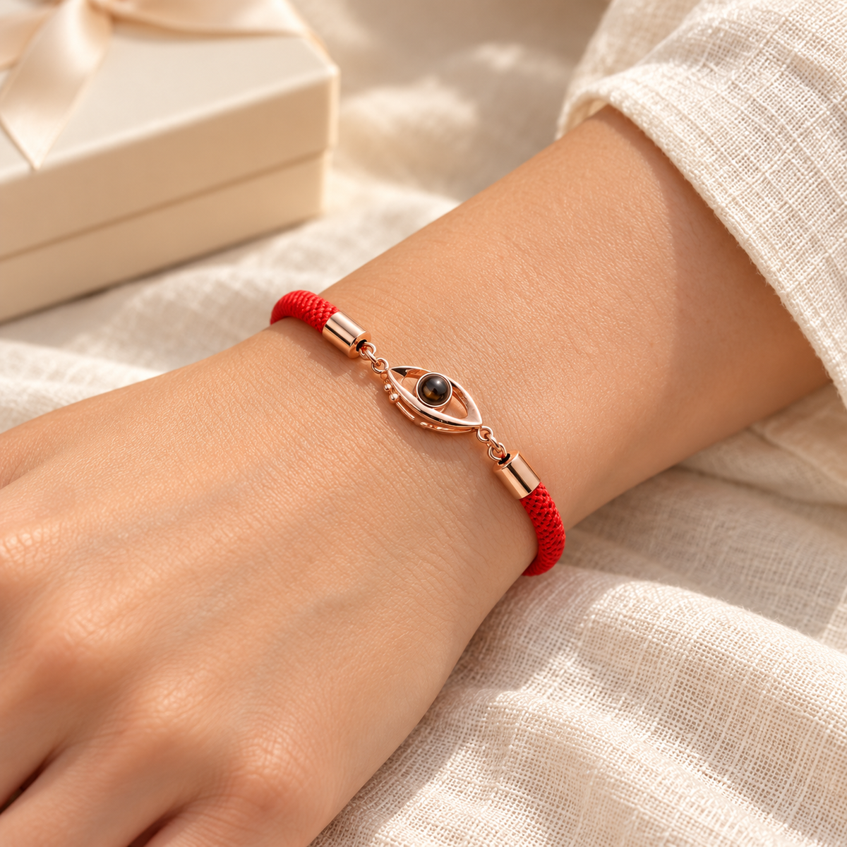 Rotes Fotoarmband mit roségoldfarbenem Augenmotiv und integrierter Fotolinse von 4MyLove, am Handgelenk getragen