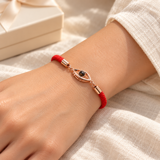 Rotes Fotoarmband mit roségoldfarbenem Augenmotiv und integrierter Fotolinse von 4MyLove, am Handgelenk getragen