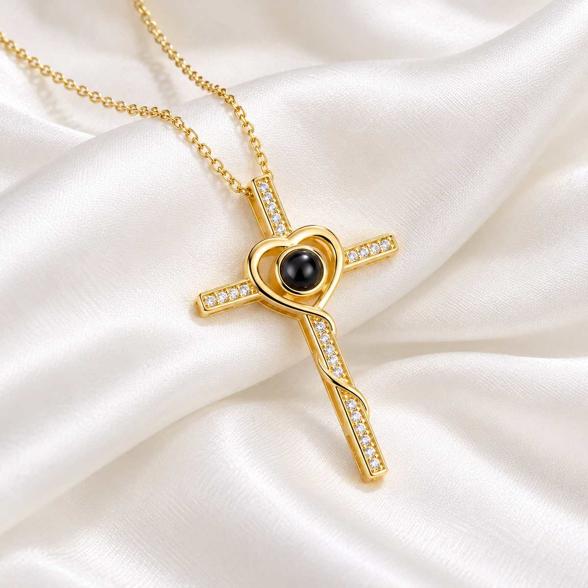 Goldene Fotokette Kreuz mit Herz und schwarzer Projektionslinse auf cremeweißer Seide