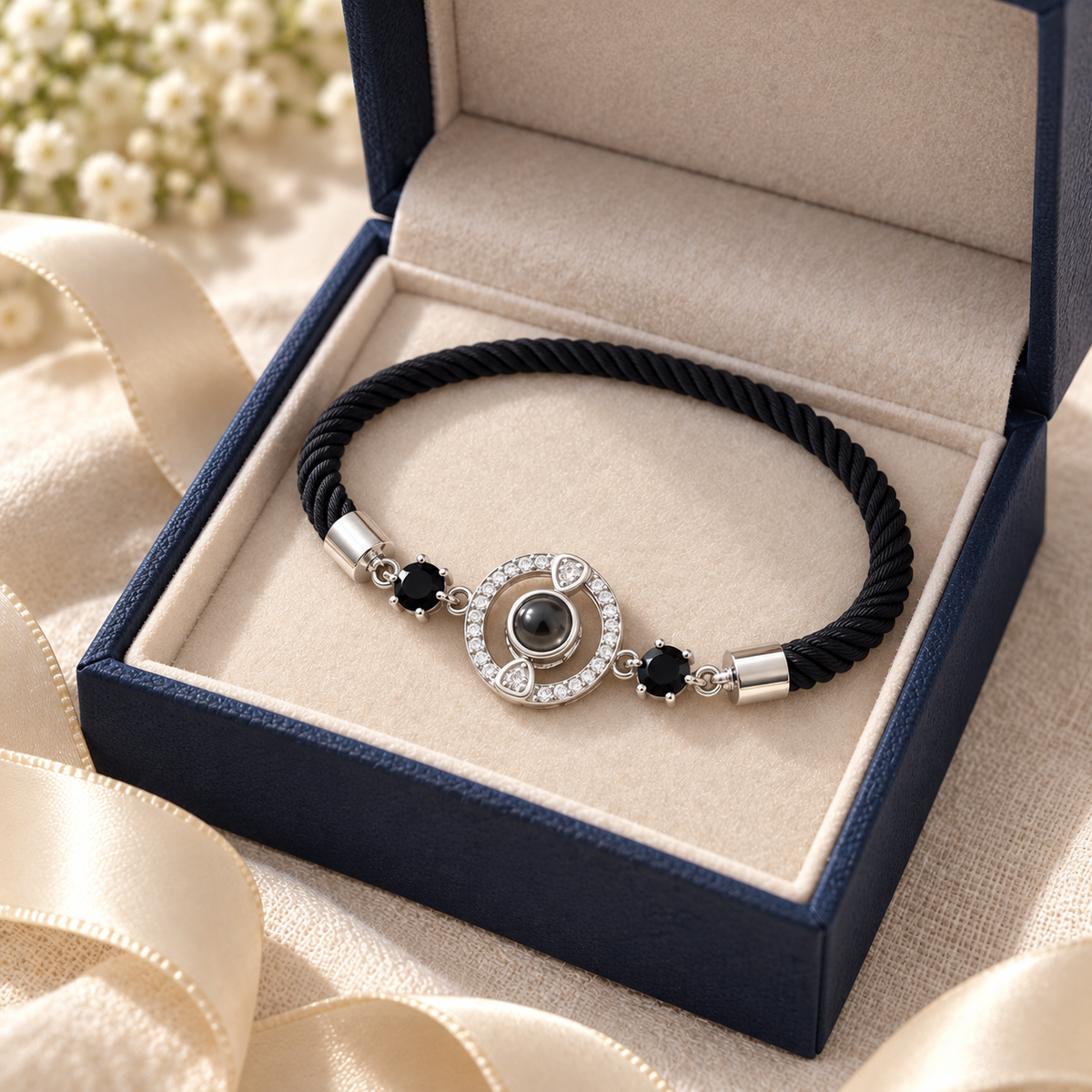 4MyLove Fotoarmband mit schwarzem Kordelband und silbernem Kristallkreis, präsentiert in einer offenen dunkelblauen Schmuckschachtel