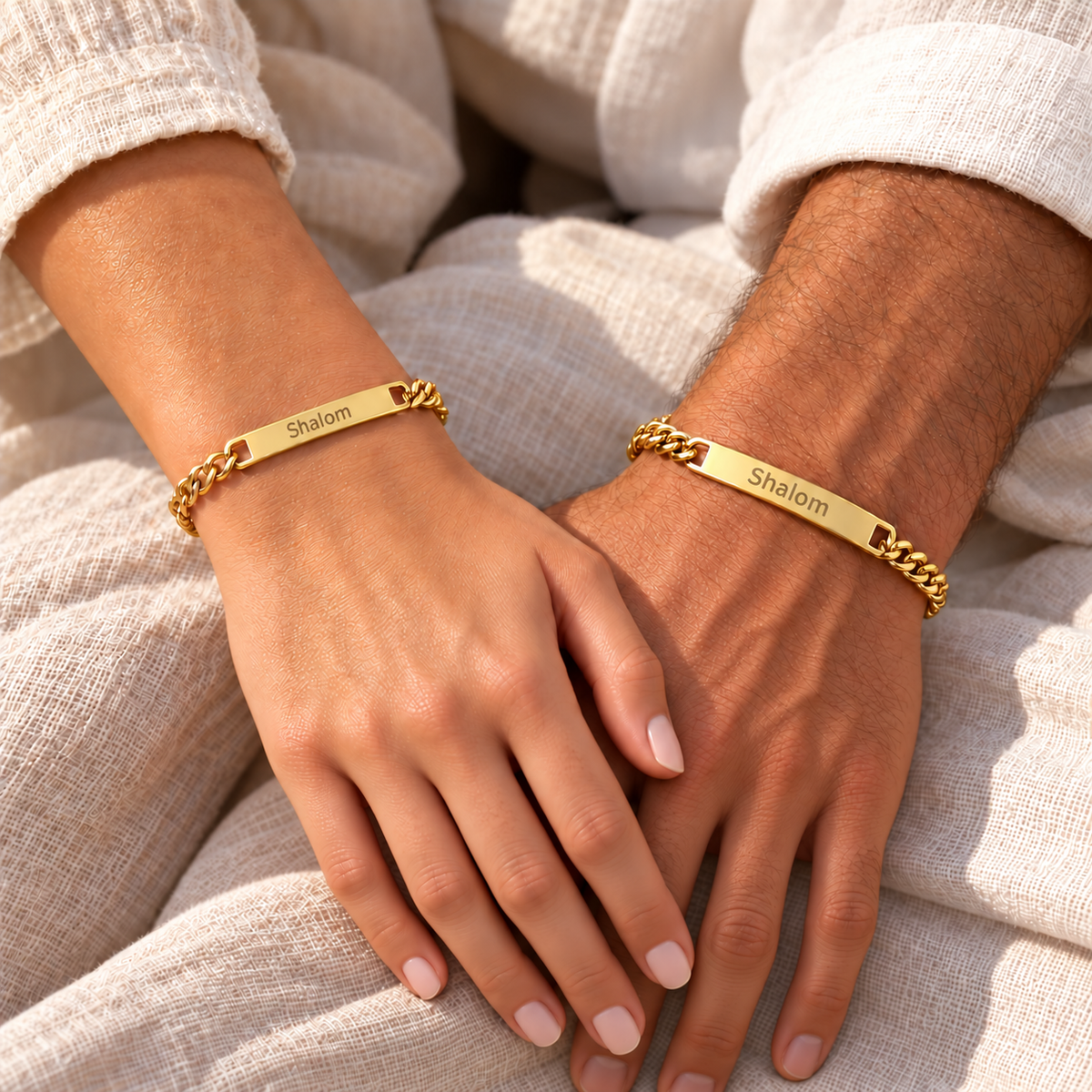 Paar trägt Partnerarmbänder mit Gravur in Gold – Pärchenarmbänder „Shalom“
