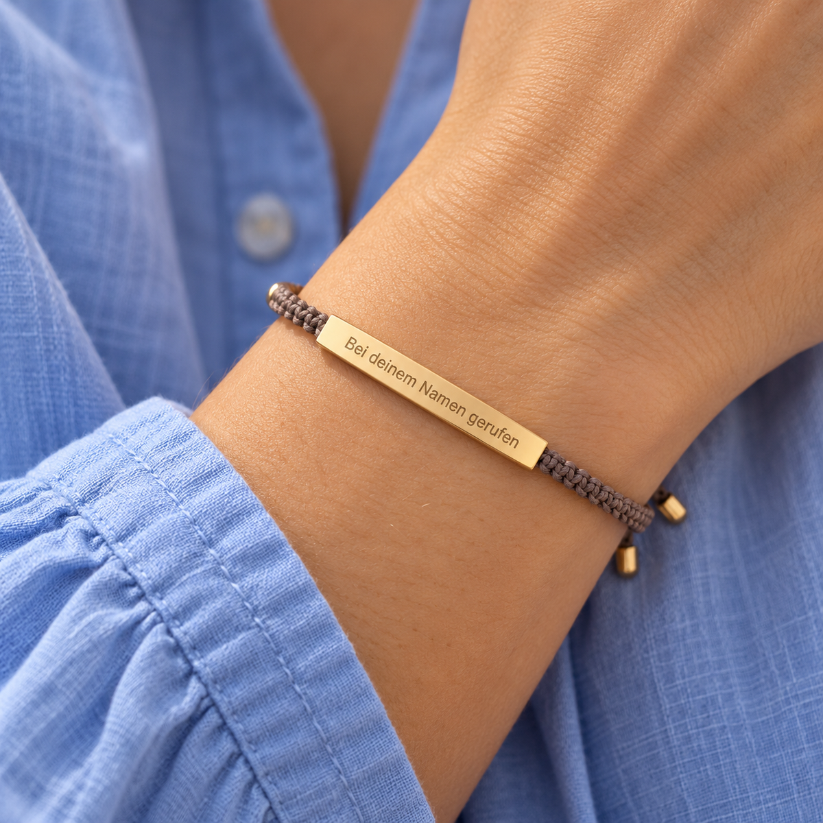 Stoffarmband mit Gravur am Handgelenk getragen – Taupe mit Goldplatte